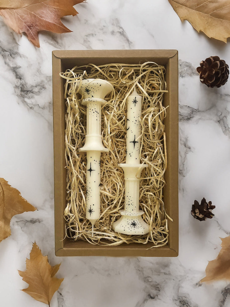Two hand painted taper candles with moon and stars in box